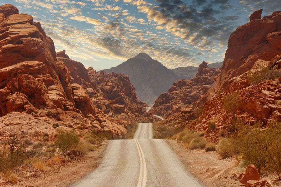 A highway rolling through red rock canyons
